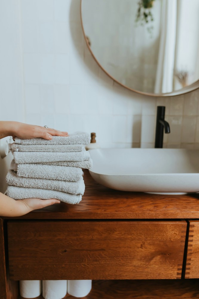 Fresh folded towels set down on a bathroom vanity